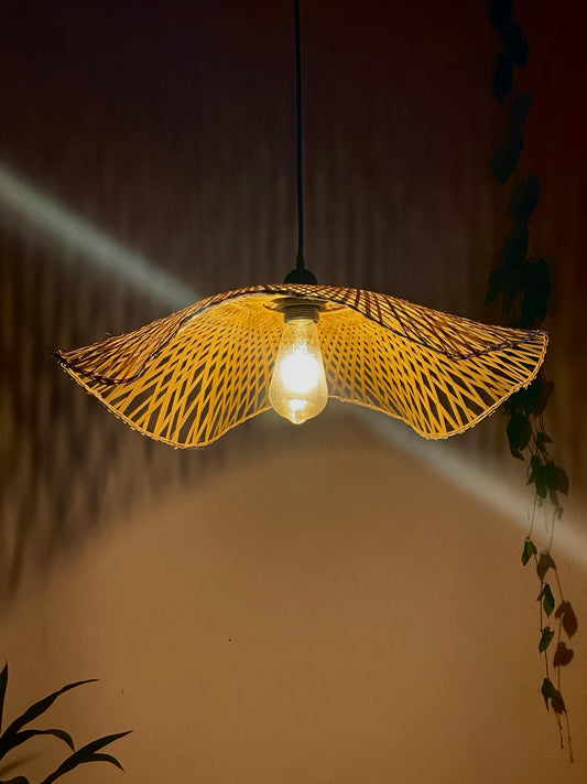 Woven pendant light with a glowing bulb against a dark background
