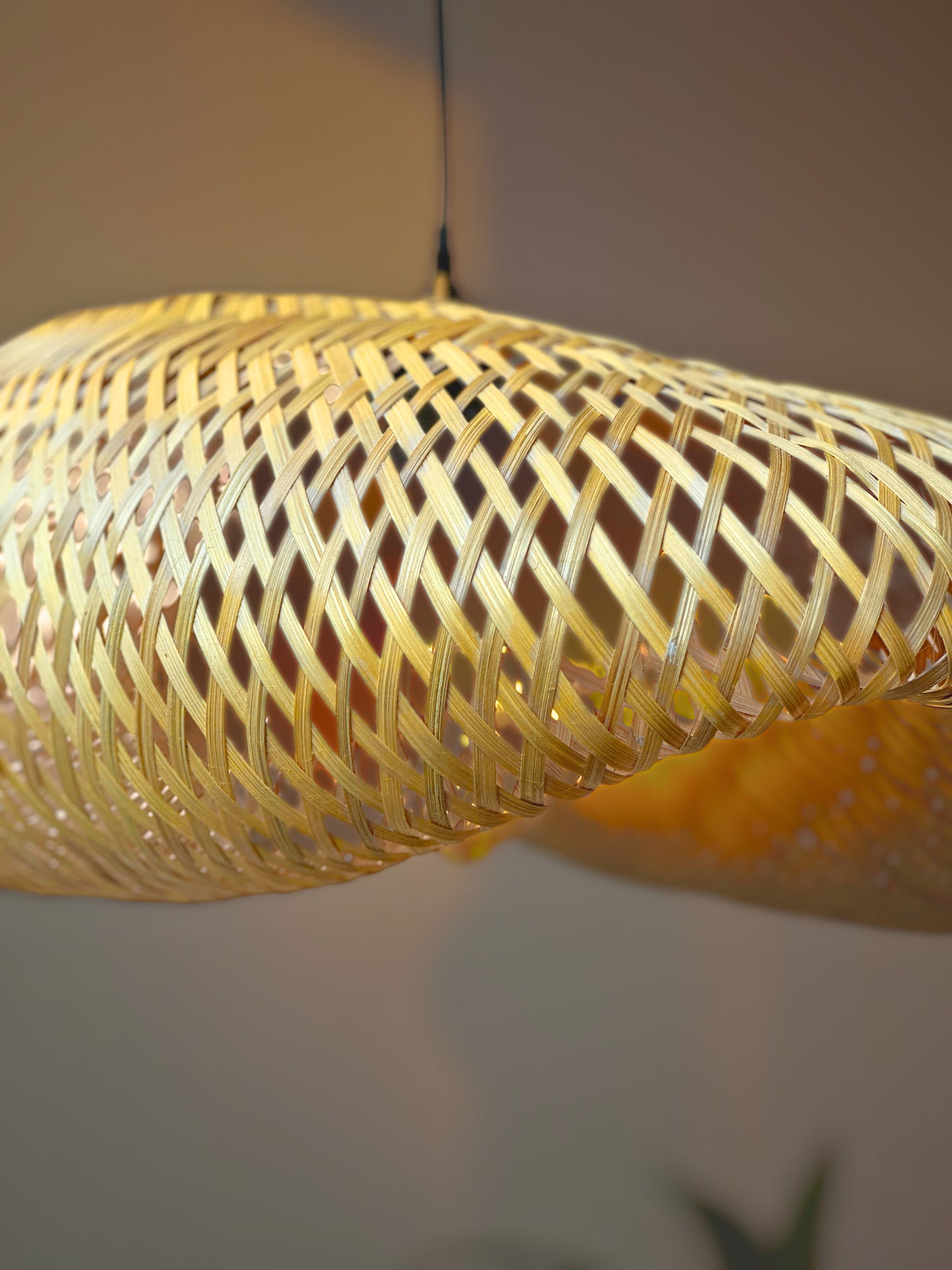 Close-up of a woven yellow lampshade against a neutral background
