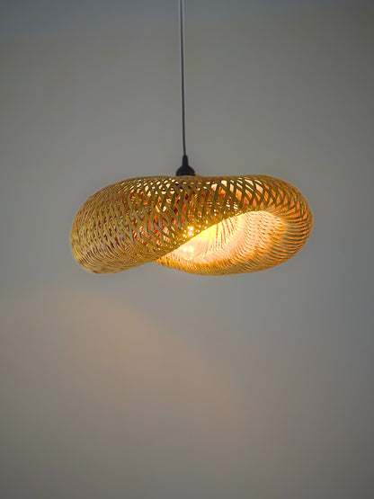 Woven pendant light with a warm glow on a plain background