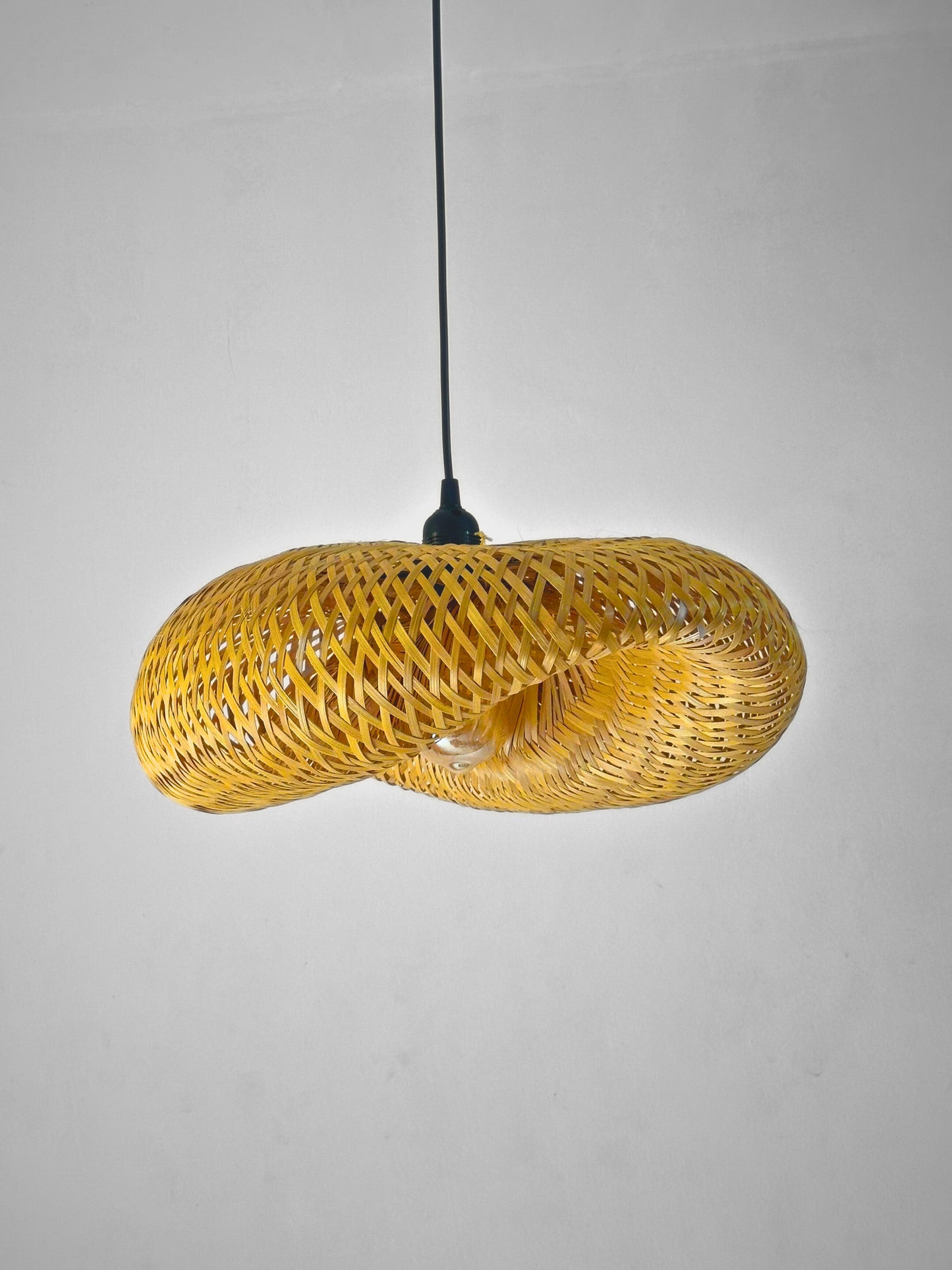 Yellow woven pendant light on a gray background